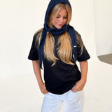 Modelfoto af pige iført navy KATHERINE balaclava, mørkblå t-shirt og hvide NANNA jeans. Alt er fra BySofieSønderby.