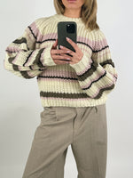 Stemningsbillede af pige der bærer en beige-lyserød KELLY striktrøje. Fra BySofieSønderby