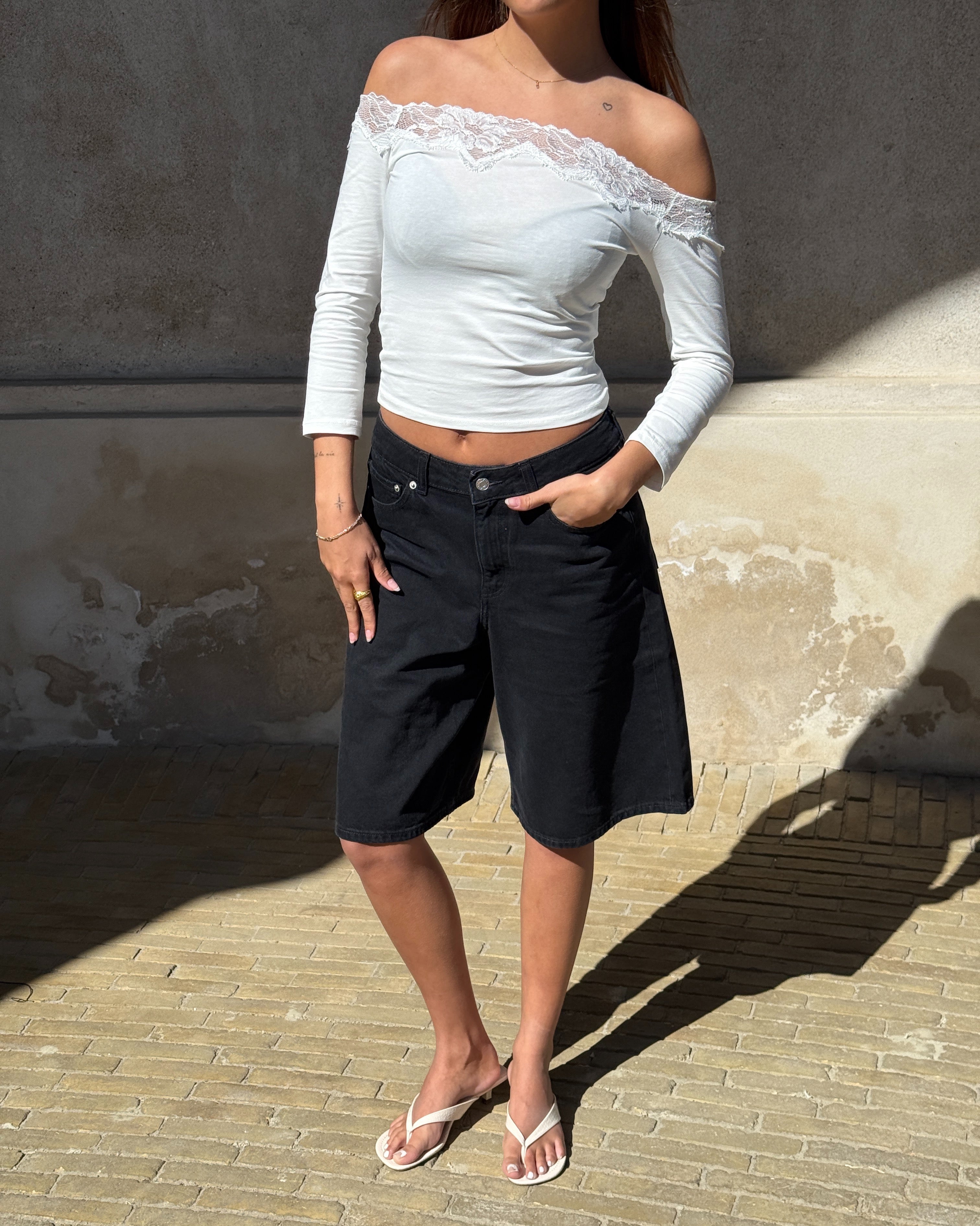 Modelbillede af KINSLEY off shoulder bluse, hvid og TOKYO jorts, sort. Begge fra BySofieSønderby
