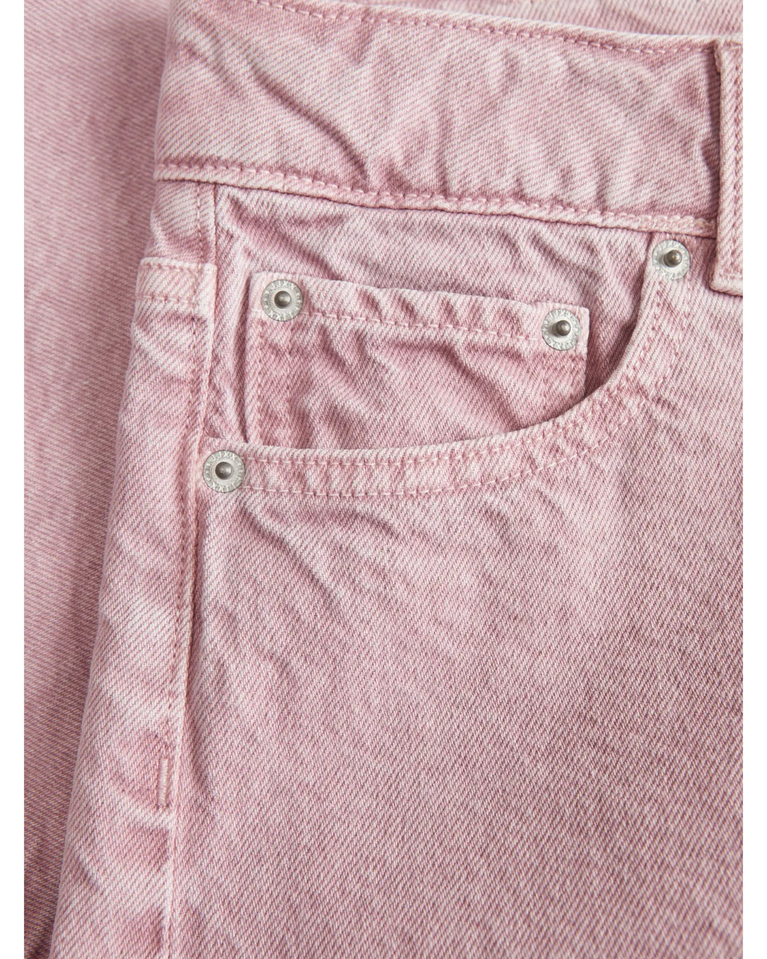 Lyserøde denimjeans med lommer; intet indhold i lommerne. Jeansene har metalnitter og er i et tæt stof, intet andet omkring dem er synligt. Ingen tekst til stede.