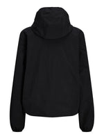 Sort jakke set bagfra, hængende i stående position. Jakken har en hætte og lange ærmer, i en neutral, ensfarvet stil uden synlige dekorationer, stillet mod en hvid baggrund.