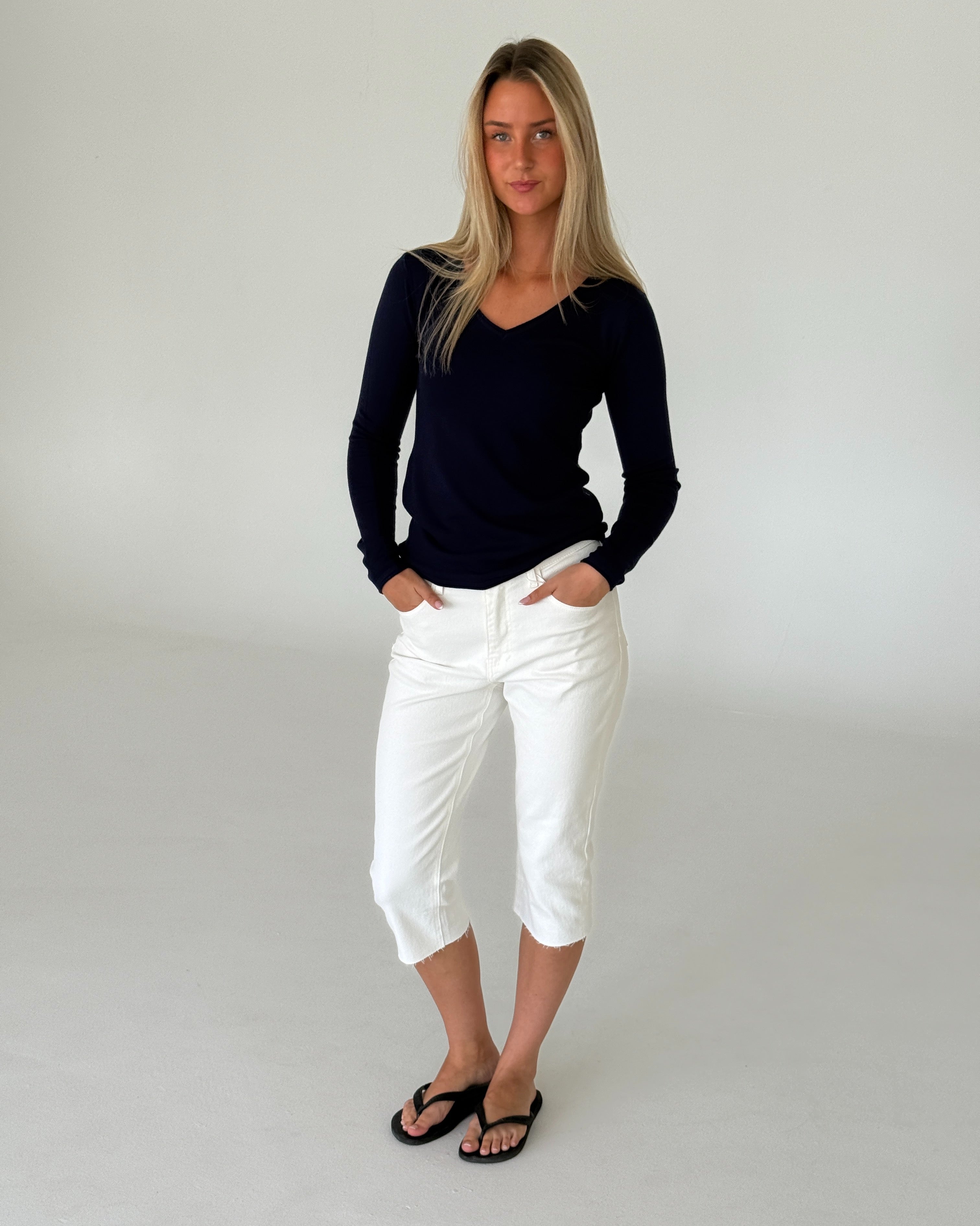 Modelbillede af LILLIE langærmet v-hals, navy og VANESSA capri bukser, hvid. Fra BySofieSønderby