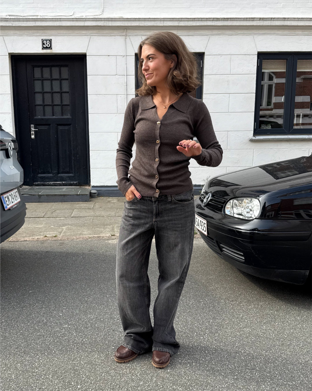 Modelfoto af pige i brun Lucce cardigan, samt grå Palermo jeans. Alt er fra BySofieSønderby