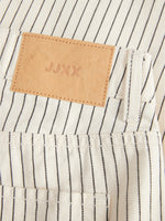 Bukselomme med sorte striber og brun lædermærke med teksten "JJXX", i et stilfuldt og moderne design.