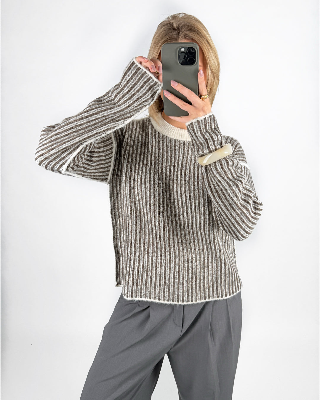 Modelfoto af pige i brun Maghna striktrøje  og grå LISA bukser. Alt er fra BySofieSønderby.