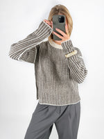 Modelfoto af pige i brun Maghna striktrøje  og grå LISA bukser. Alt er fra BySofieSønderby.