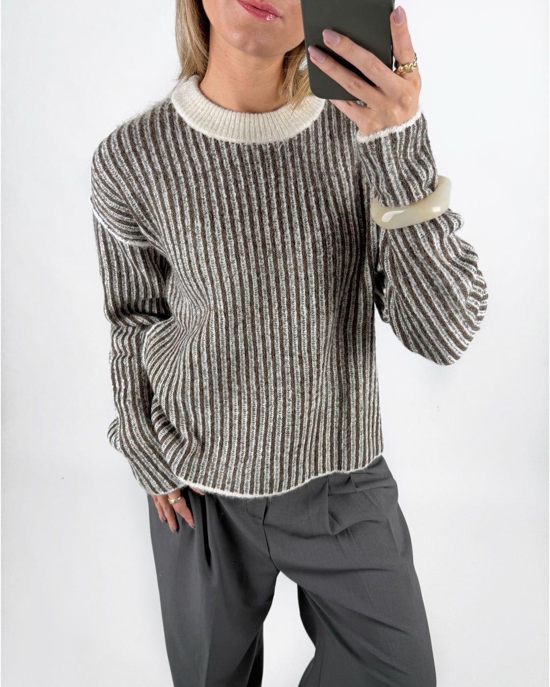 Modelfoto af pige i brun Maghna striktrøje  og grå LISA bukser. Alt er fra BySofieSønderby.