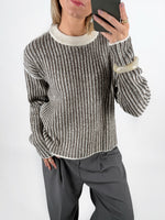 Modelfoto af pige i brun Maghna striktrøje  og grå LISA bukser. Alt er fra BySofieSønderby.