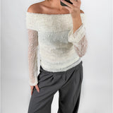 Modelfoto af pige i cremefarvet MAISY off-shoulder blondebluse og grå LISA bukser. Alt er fra BySofieSønderby.