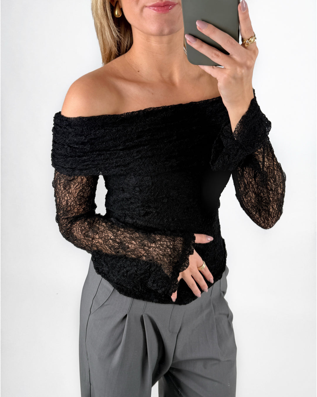 Modelfoto af pige i sort MAISY off-shoulder blondebluse og grå LISA bukser. Alt er fra BySofieSønderby.