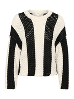 Sort-hvid strikket sweater med brede lodrette striber hænger mod en neutral baggrund. I nakken er der en mærkat med teksten "soaked".
