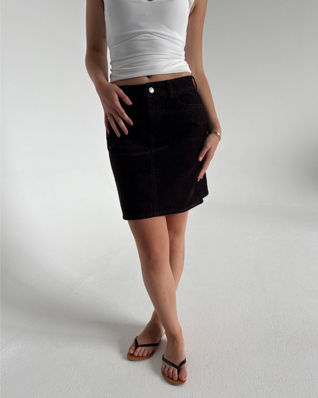 Modelfoto af pige der bærer Mia nederdel i brun, samt hvid top. Alt fra BySofieSønderby