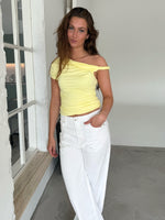 Modelfoto af pige med MILENA off shoulder top, gul og NANNA jeans, hvid - begge fra BySofieSønderby