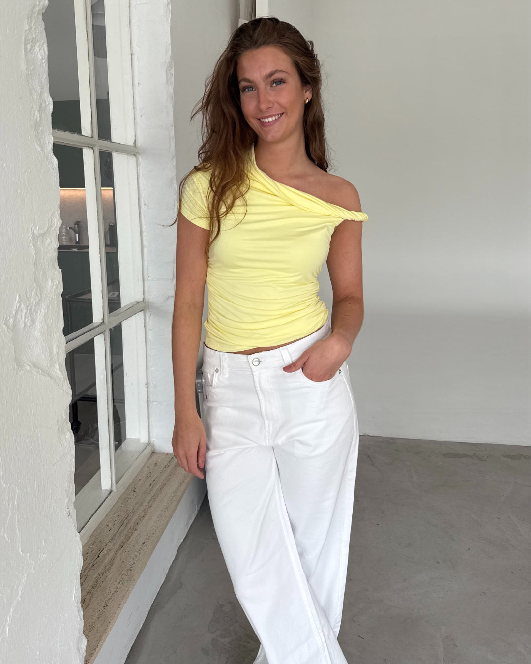 Modelfoto af pige med MILENA off shoulder top, gul og NANNA jeans, hvid - begge fra BySofieSønderby