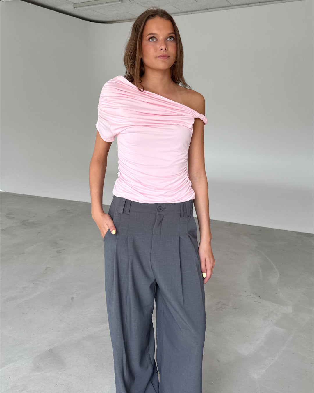 Modelfoto af pige med MILENA off shoulder top, lyserød og MILAN bukser, grå - begge fra BySofieSønderby