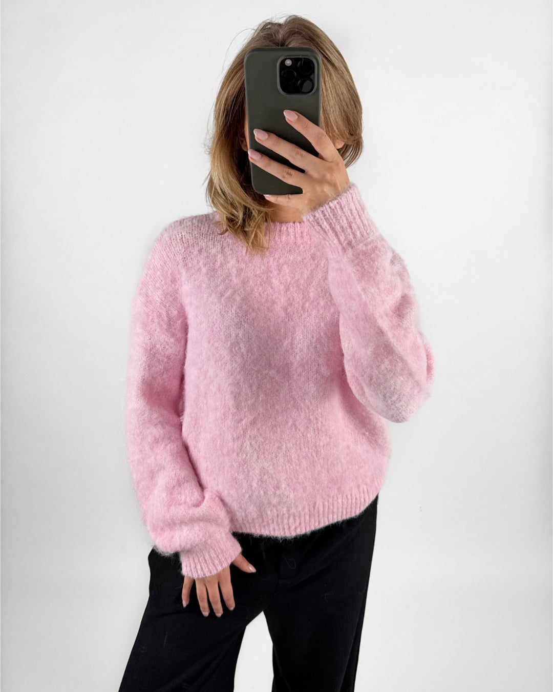 Modelfoto af pige med lyserød MILLY strikbluse, samt sorte ELLIS bukser. Set forfra. Alt er fra BySofieSønderby