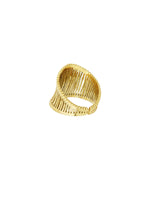 En guldarmbånd med et snoet, åbent design, ligger på en hvid baggrund. Armbåndet har en bred struktur med parallelle stænger, der giver en let og elegant udstråling.