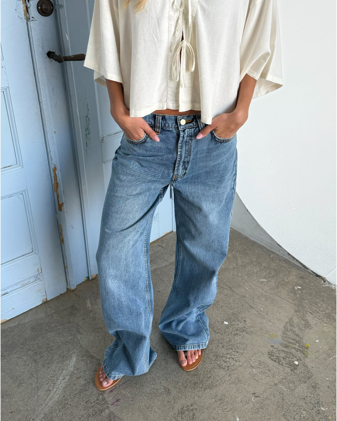 Modelfoto af pige der bærer blå Nanna jeans og beige Breeze top. Alt fra BySofieSønderby