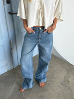 Modelfoto af pige der bærer blå Nanna jeans og beige Breeze top. Alt fra BySofieSønderby