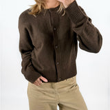 Modelfoto af pige med brun NATALIE strik cardigan, samt beige TOKYO jeans. Set forfra. Alt er fra BySofieSønderby