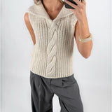 Modelfoto af pige i beige OCEAN strikvest med kabelstrik-detalje  og grå LISA bukser. Alt er fra BySofieSønderby.