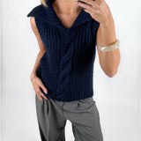 Modelfoto af pige i navy OCEAN strikvest med kabelstrik-detalje  og grå LISA bukser. Alt er fra BySofieSønderby.