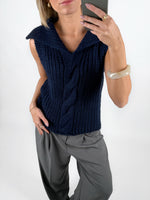 Modelfoto af pige i navy OCEAN strikvest med kabelstrik-detalje  og grå LISA bukser. Alt er fra BySofieSønderby.