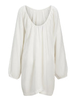 Hvid løstsiddende bluse med lange ærmer hænger frit mod en neutral baggrund. Stoffet har en let, krøllet tekstur, og blusen har en rund udskæring.