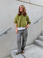 Modelfoto af pige i grøn POPPY strik, samt grå NANNA jeans. Alt er fra BySofieSønderby.