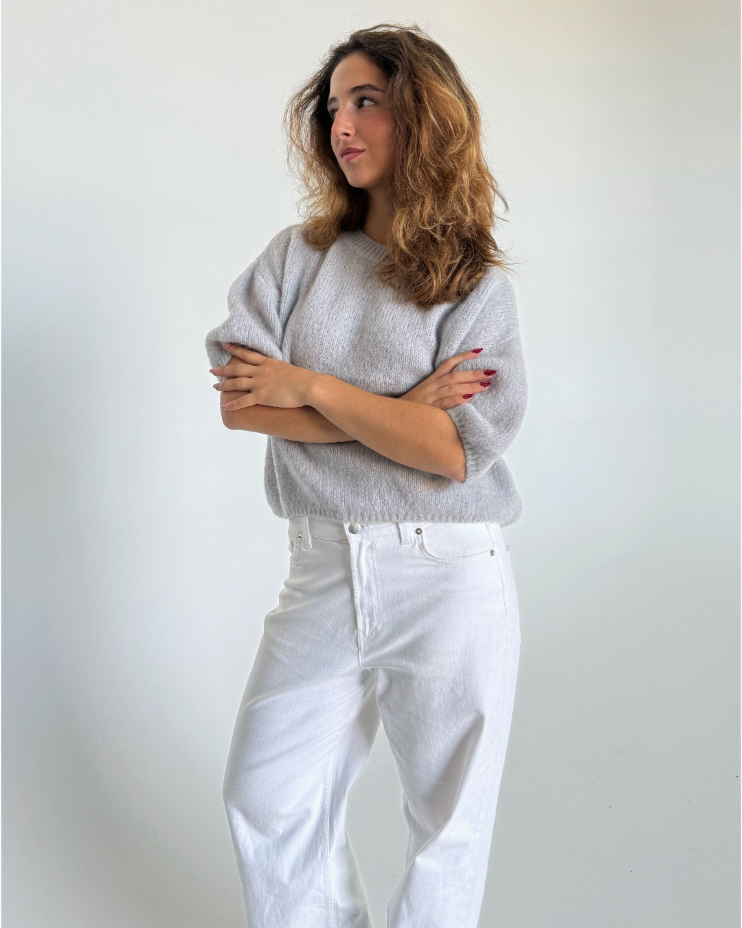 Modelfoto af pige i lysegrå Poppy strik t-shirt og hvide Nanna jeans. Alt er fra BySofieSønderby