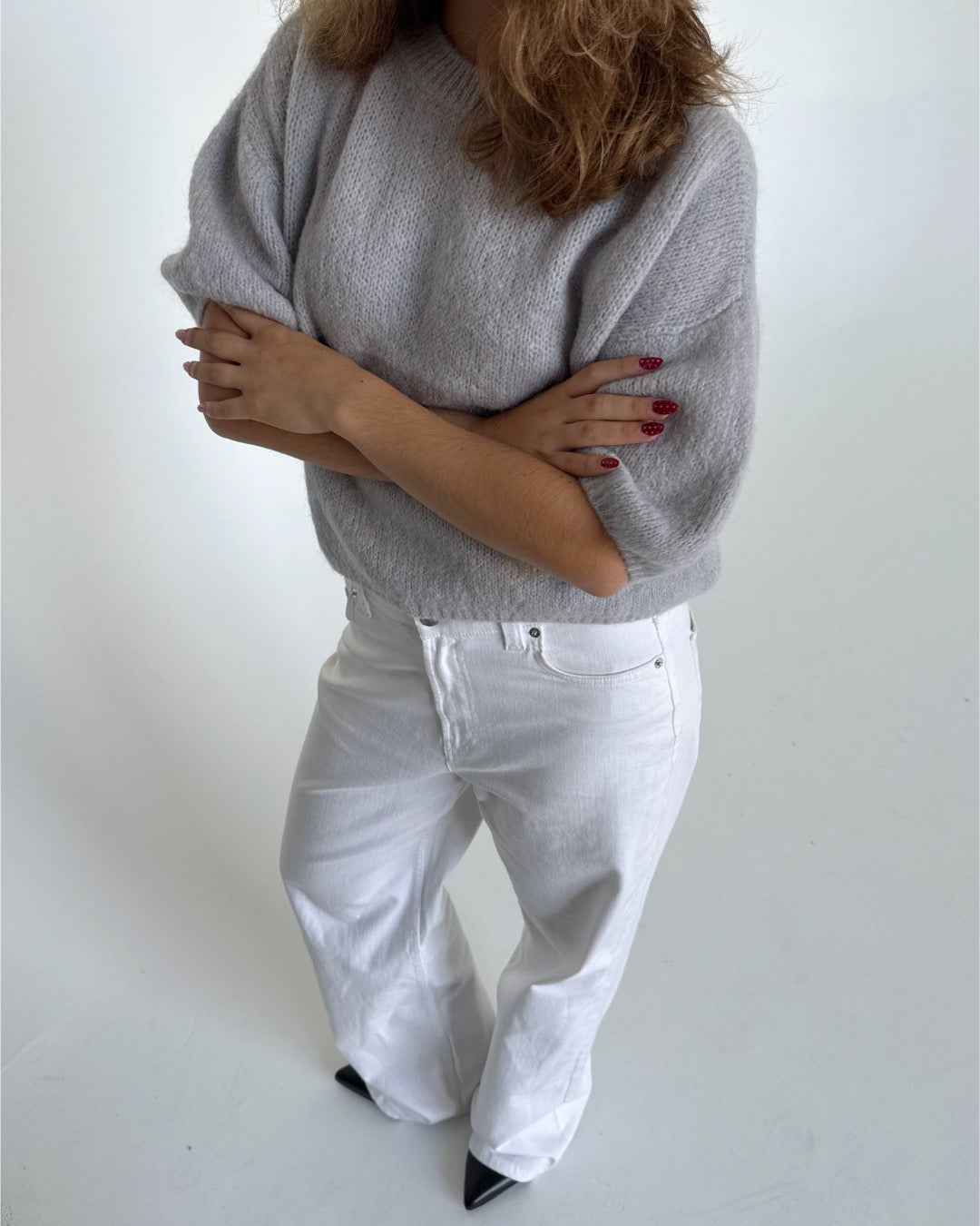 Modelfoto af pige i lysegrå Poppy strik t-shirt og hvide Nanna jeans. Alt er fra BySofieSønderby