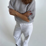 Modelfoto af pige i lysegrå Poppy strik t-shirt og hvide Nanna jeans. Alt er fra BySofieSønderby