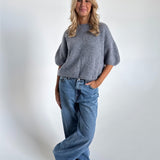 Modelfoto af pige i mørkegrå Poppy strik t-shirt og hvide Nanna jeans. Alt er fra BySofieSønderby