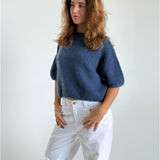 Modelfoto af pige i blå Poppy strik t-shirt og hvide Nanna jeans. Alt er fra BySofieSønderby