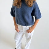 Modelfoto af pige i blå Poppy strik t-shirt og hvide Nanna jeans. Alt er fra BySofieSønderby