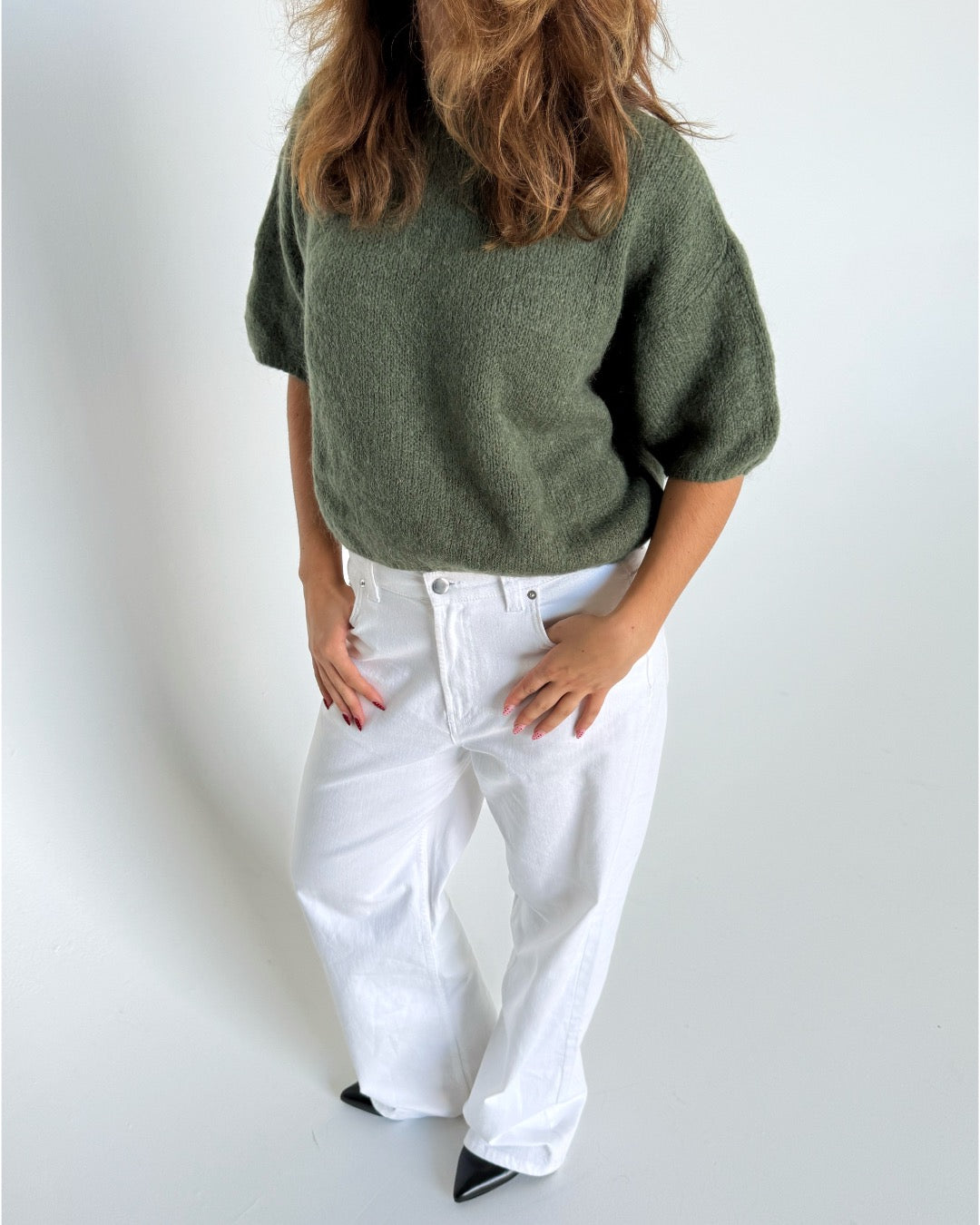 Modelfoto af pige i kaki Poppy strik t-shirt og hvide Nanna jeans. Alt er fra BySofieSønderby
