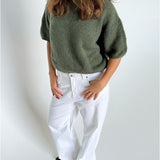 Modelfoto af pige i kaki Poppy strik t-shirt og hvide Nanna jeans. Alt er fra BySofieSønderby