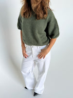 Modelfoto af pige i kaki Poppy strik t-shirt og hvide Nanna jeans. Alt er fra BySofieSønderby