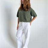 Modelfoto af pige i kaki Poppy strik t-shirt og hvide Nanna jeans. Alt er fra BySofieSønderby
