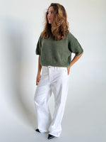 Modelfoto af pige i kaki Poppy strik t-shirt og hvide Nanna jeans. Alt er fra BySofieSønderby