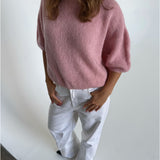 Modelfoto af pige i lyserød Poppy strik t-shirt og hvide Nanna jeans. Alt er fra BySofieSønderby
