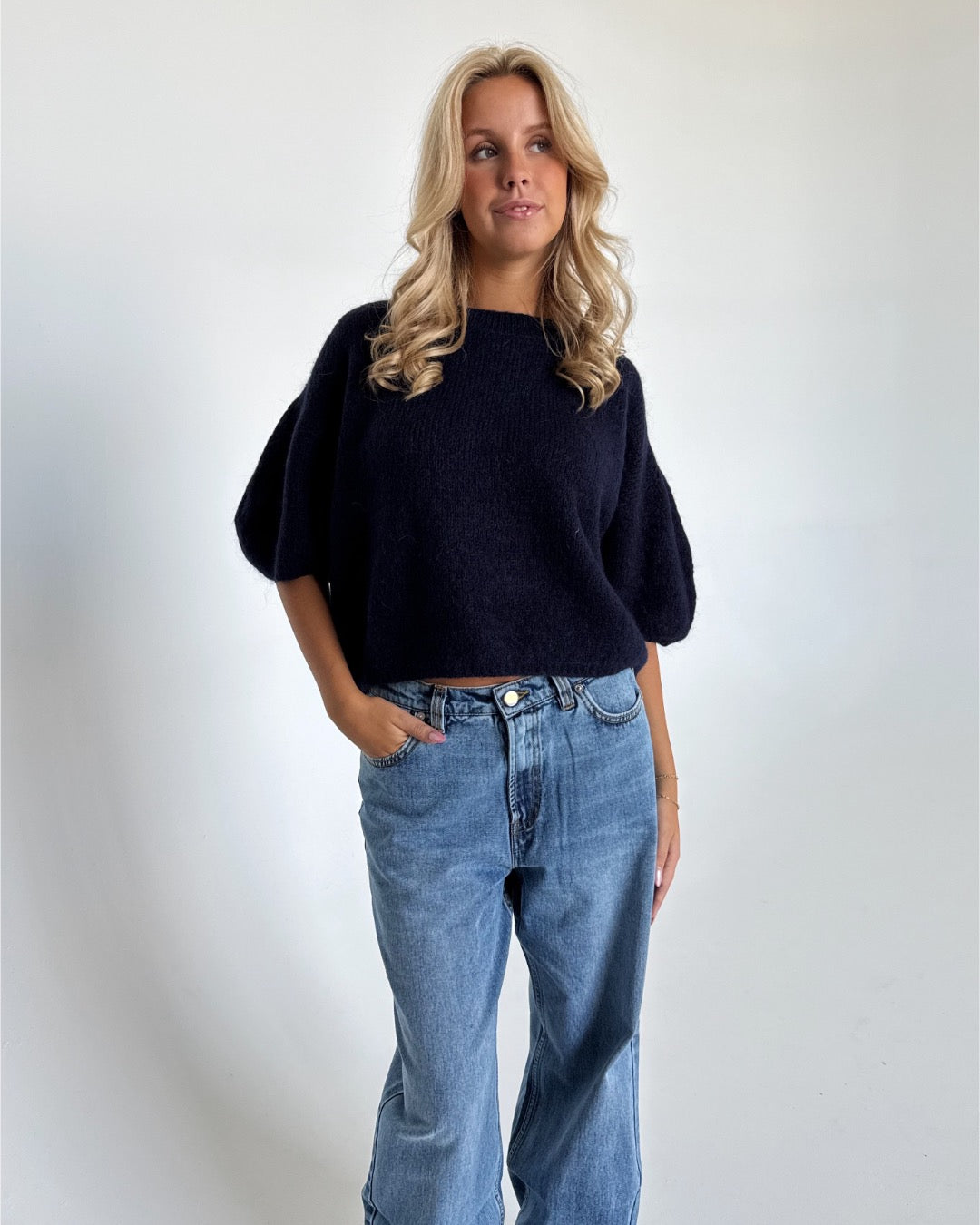 Modelfoto af pige i navy Poppy strik t-shirt og blå Nanna jeans. Alt er fra BySofieSønderby