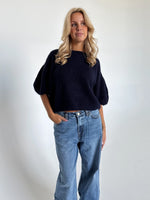 Modelfoto af pige i navy Poppy strik t-shirt og blå Nanna jeans. Alt er fra BySofieSønderby