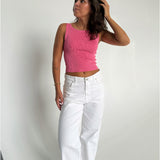 Modelfoto af pige som bærer en Posie top i pink, samt et par hvide Nanna jeans. Baggrund hvid. Alt fra By Sofie Sønderby