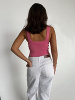 Modelfoto af pige som bærer en Posie top i pink, samt et par hvide Nanna jeans. Baggrund hvid. Alt fra By Sofie Sønderby