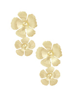 Guldblomsterøreringe med tre lagdelte kronblade og en kugleformet midte, opstillet mod en hvid baggrund, der fremhæver deres elegante, polerede tekstur og delikate blomstermotiv.