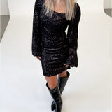 Modelfoto af pige i lilla RAYA kjole med pailetter, samt sorte støvler. Alt er fra BySofieSønderby.