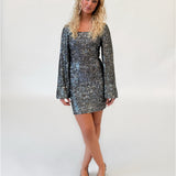 Modelfoto af pige i sølvfarvet RAYA kjole med pailetter. Alt er fra BySofieSønderby.