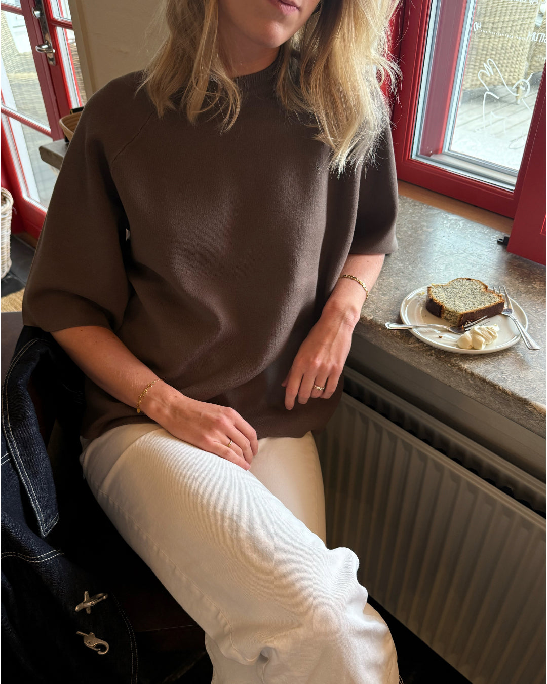 Modelfoto af pige der bærer Reynard strik t-shirt i brun, samt hvide bukser. Alt fra BySofieSønderby