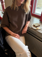Modelfoto af pige der bærer Reynard strik t-shirt i brun, samt hvide bukser. Alt fra BySofieSønderby